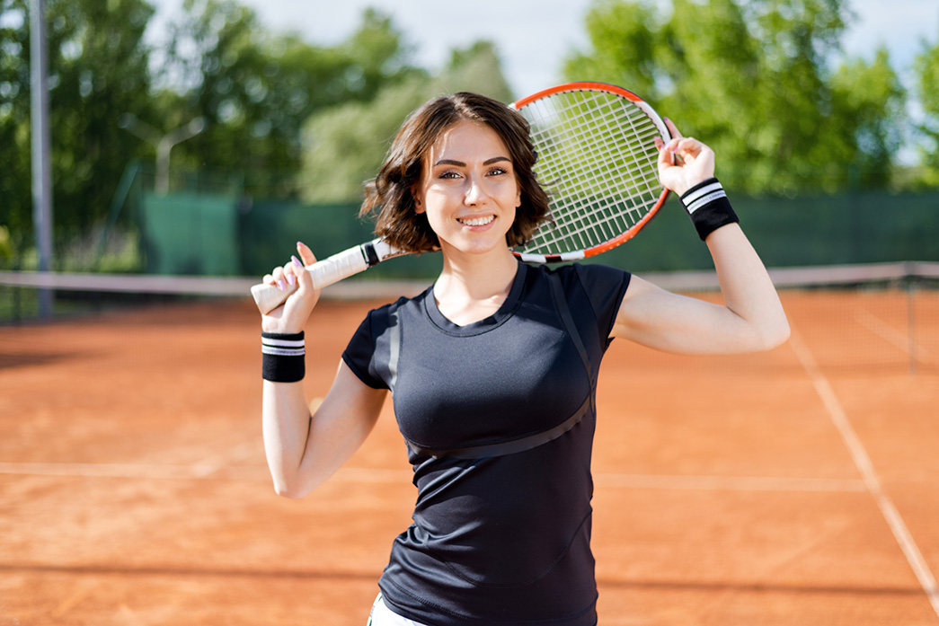 smiling lady at a tennis court